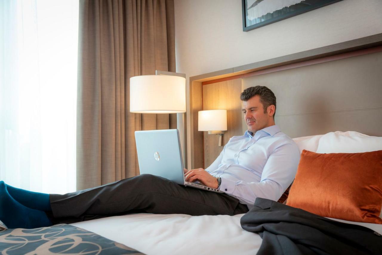 Clayton Hotel Dublin Airport Coolock Ngoại thất bức ảnh A man working on a laptop in a hotel room